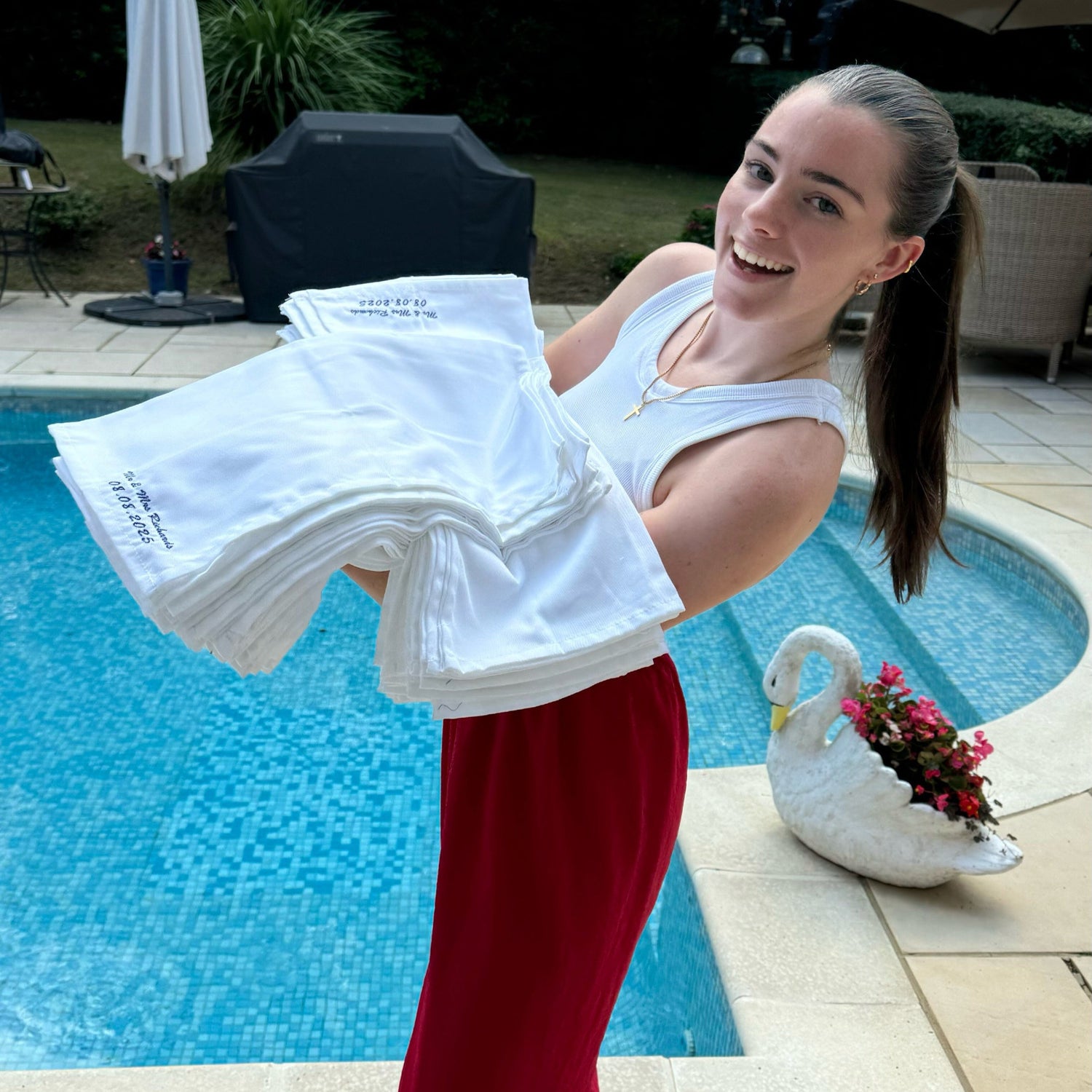 Woman holding white towels by a poolside