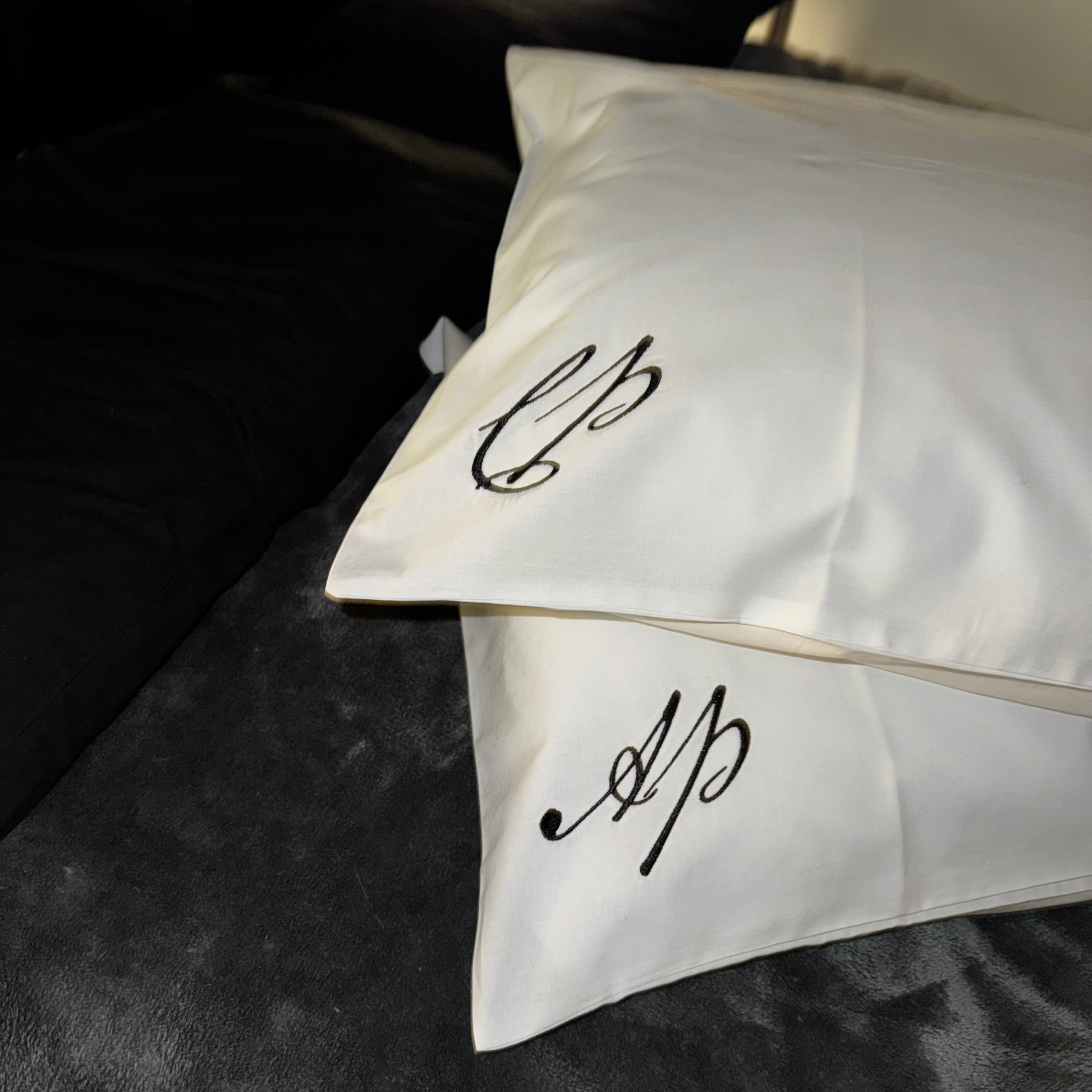 White pillows with monogram on a dark surface