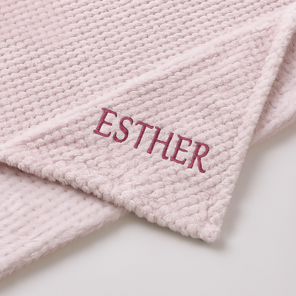 Pink textured blanket with 'ESTHER' embroidered on it